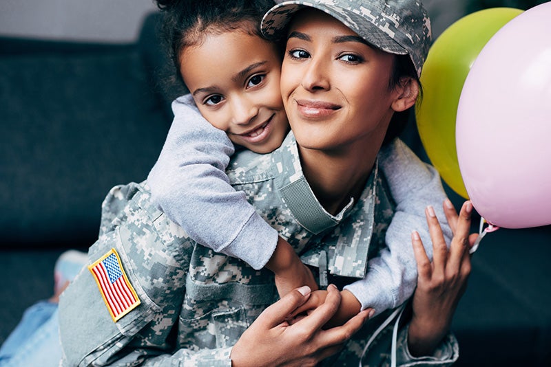 military family mom in military fatigues with daughterr smiling